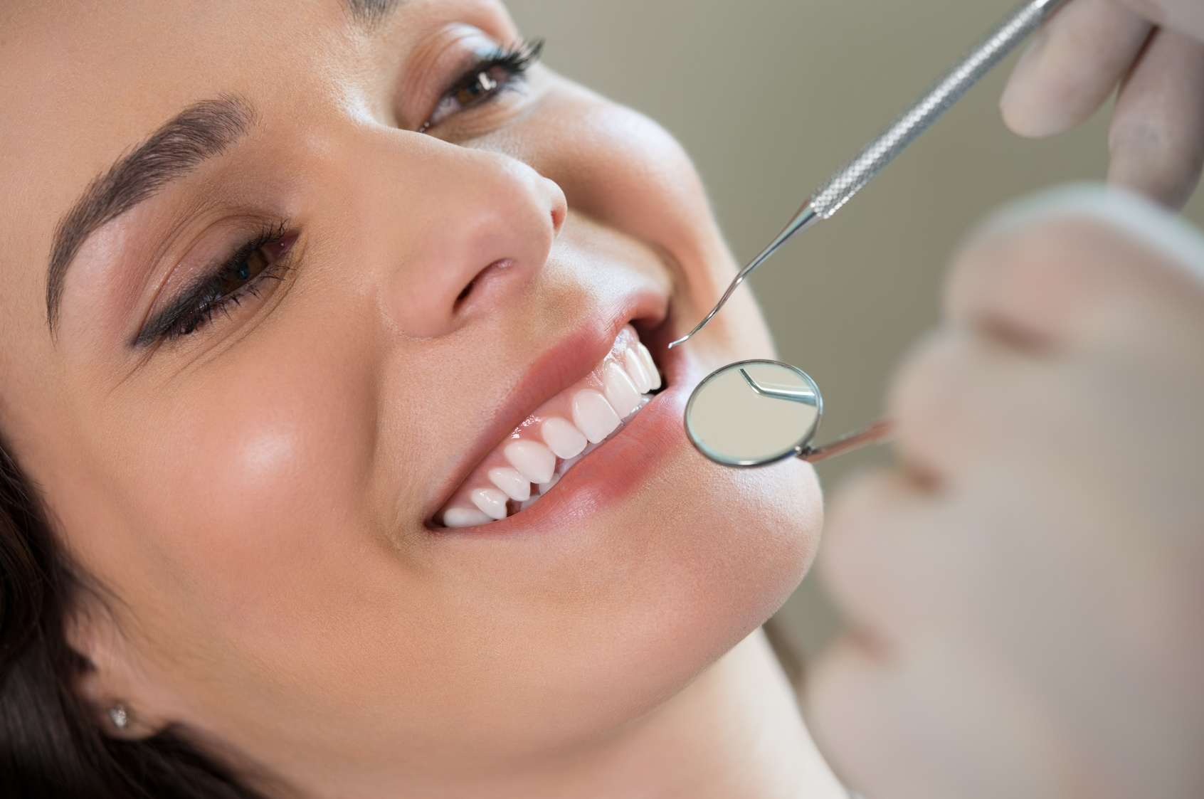 Closeup of dentist examining young woman's teeth